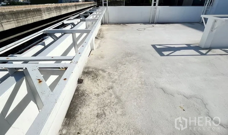 อาคารพาณิชย์ ให้เช่าในPhra Khanong, Bangkok - ดาดฟ้าเปิดโล่งพื้นสีขาว พร้อมโครงเหล็ก ติดแนวรถไฟฟ้ายกระดับ.