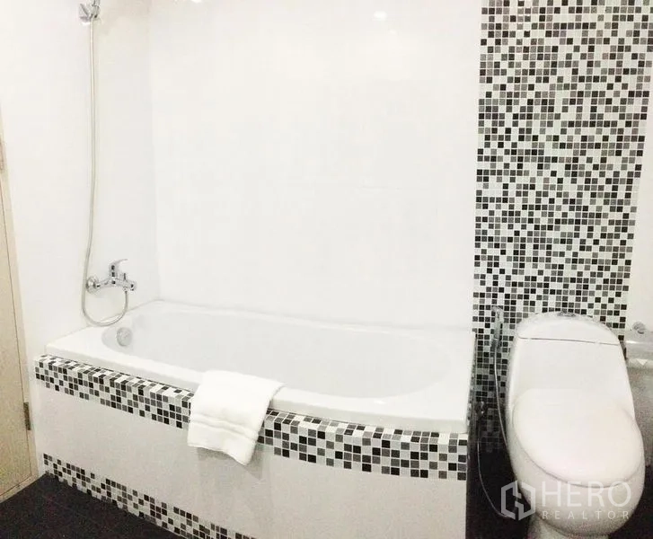 คอนโด ให้เช่าในKhlong Toei, Bangkok - ห้องน้ำสมัยใหม่พร้อมอ่างอาบน้ำสีขาว กระเบื้องโมเสก ฝักบัวติดผนัง และชักโครกข้างกัน