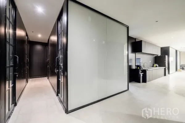 办公空间 出租或出售在Huai Khwang, Bangkok - 现代走廊，磨砂玻璃隔断与内置茶水台并列。