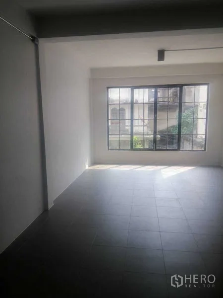 Shophouse for rent in Khlong Toei, Bangkok - Upper-floor room with large grid windows bringing natural light.