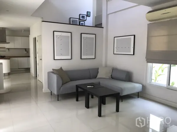 独立式住宅 出租或出售在Saphan Sung, Bangkok - 明亮客厅，灰色转角沙发，亮面地砖，开放式布局。