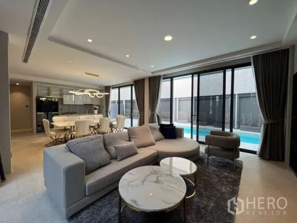 独立式住宅 出租在Suan Luang, Bangkok - 开放式客餐厅，大沙发，推拉玻璃门通往私家泳池