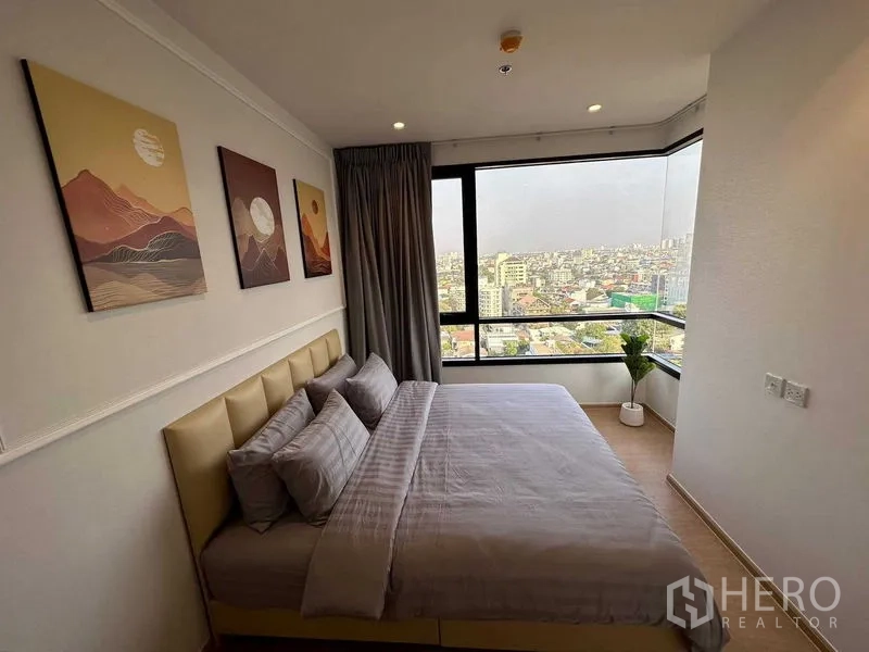 公寓 出售 - 主卧带转角落地窗与城市景观，暖色系装饰。