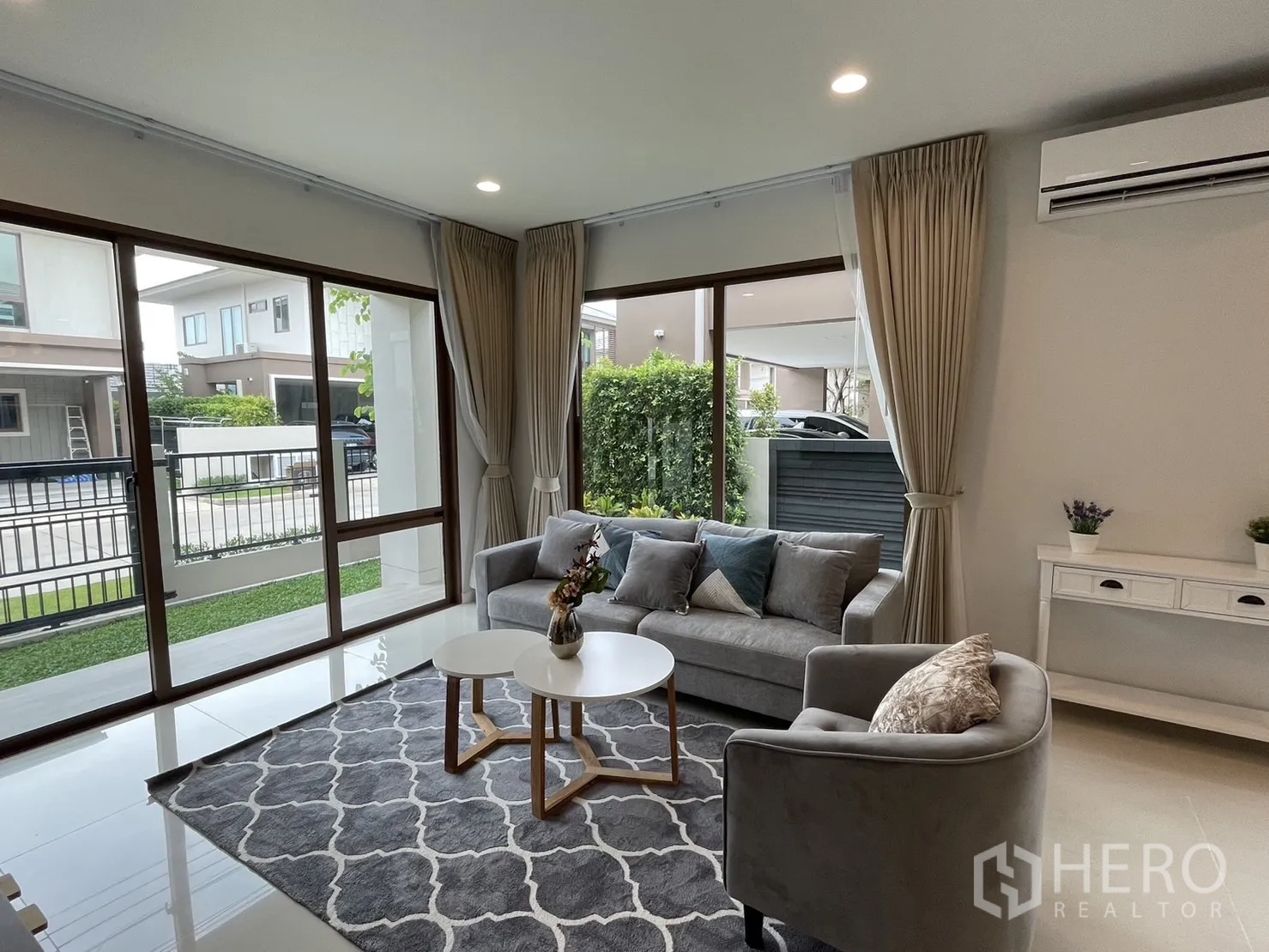 Detached House for rent in Bang Kapi, Bangkok - Bright living room with floor-to-ceiling windows, AC, and access to the front lawn.