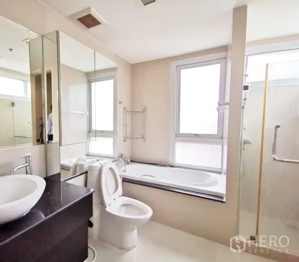 公寓 出租在Khlong Toei, Bangkok - 主卫配窗边浴缸、独立玻璃淋浴与台盆柜。