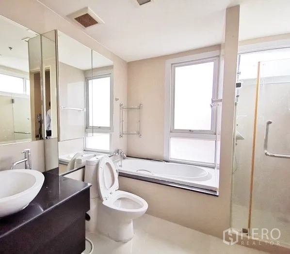 公寓 出租在Khlong Toei, Bangkok - 主卫配窗边浴缸、独立玻璃淋浴与台盆柜。