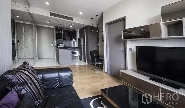 公寓 出租在Khlong Toei, Bangkok - 开放式客厅，皮沙发、电视柜与紧凑厨房及用餐区，素坤逸公寓