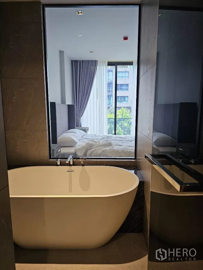 公寓 出租在Watthana, Bangkok - 奢华卫浴，设独立浴缸，可透窗望向卧室。