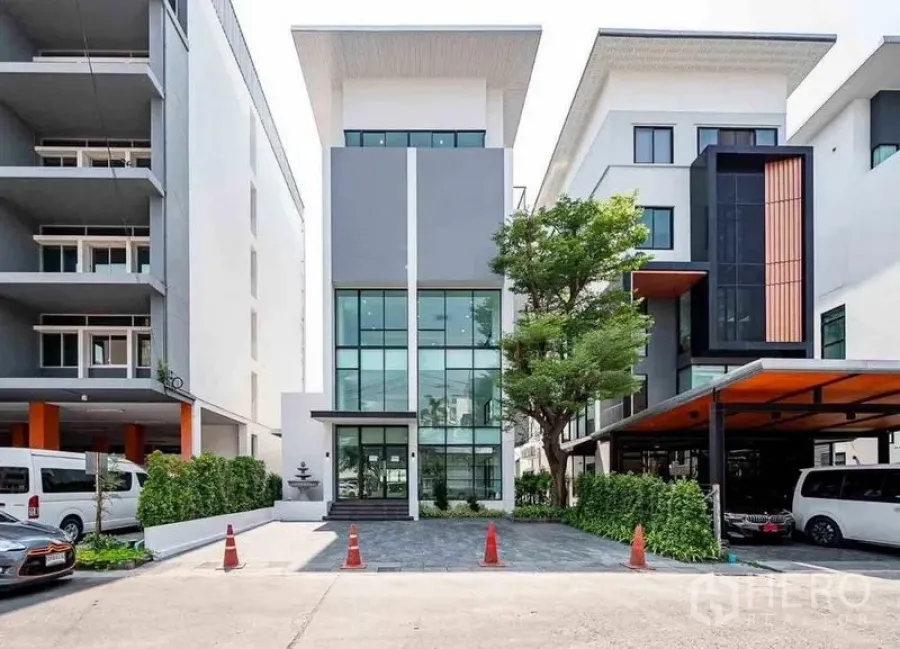Home Office for rent in Suan Luang, Bangkok - Street-side view of the modern home office frontage with tall windows and landscaped entry.