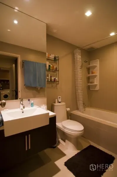 公寓 出租在Khlong Toei, Bangkok - 现代卫浴，带浴缸、台盆大镜与坐便器，嵌灯照明明亮。