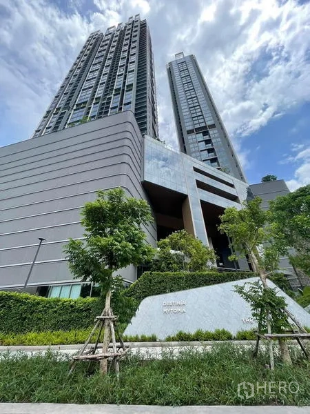 Condominium for rent in Samut Prakan - Contemporary twin condominium towers with a landscaped entrance.