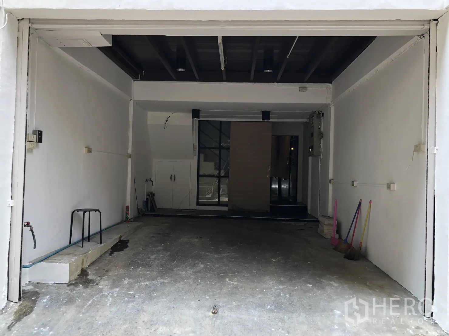 อาคารพาณิชย์ ให้เช่า - ทางเข้าชั้นล่างแบบโรงรถ ประตูยกเปิดและพื้นคอนกรีต