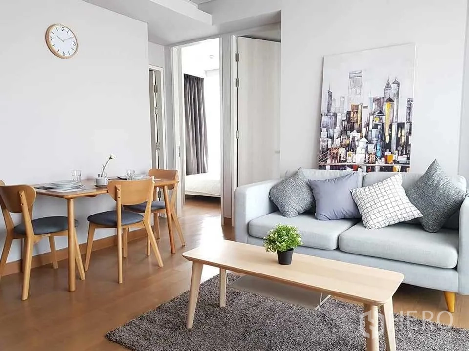 คอนโด ให้เช่าในKhlong Toei, Bangkok - ห้องนั่งเล่นสว่าง โซฟาสีเทา โต๊ะกลาง ชุดโต๊ะอาหาร และทางเข้าห้องนอน