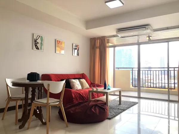 คอนโด ให้เช่าหรือขายในKhlong Toei, Bangkok - มุมนั่งเล่นหันออกไประเบียง โต๊ะกลางและพรม เห็นสกายไลน์ผ่านกระจกบานใหญ่