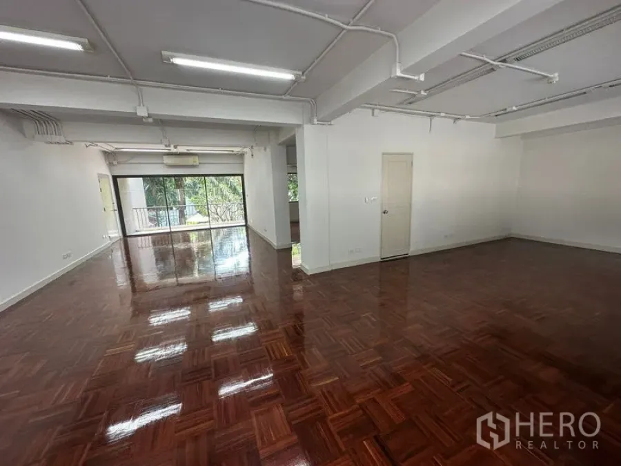 办公空间 出租 - 大面积开放办公区，外露顶棚照明与光亮木地板。