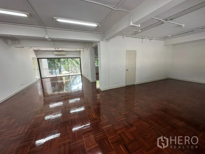 办公空间 出租 - 大面积开放办公区，外露顶棚照明与光亮木地板。