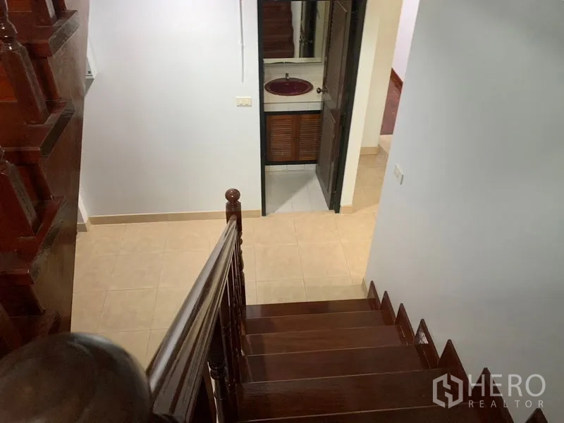 บ้าน ให้เช่าในKhlong Toei, Bangkok - บันไดไม้ลงสู่โถงชั้นล่าง เห็นประตูห้องน้ำพร้อมอ่างล้างหน้า