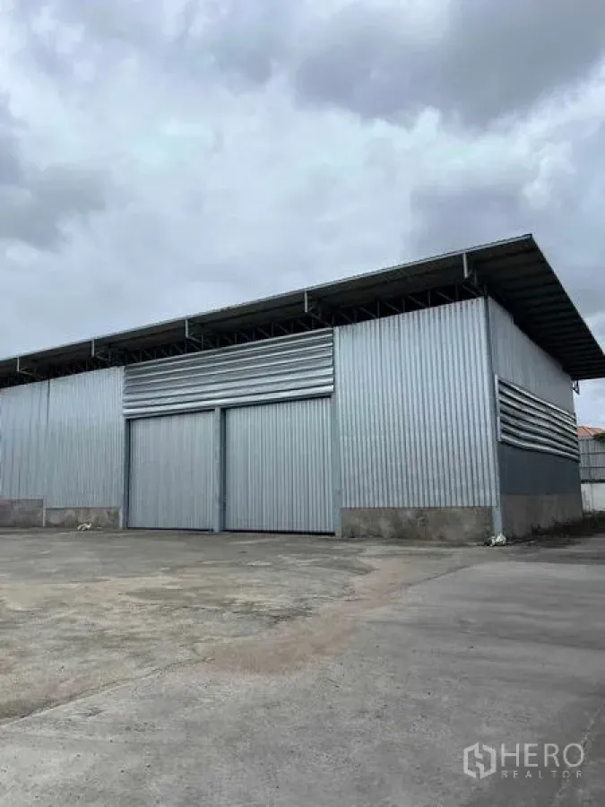 คลังสินค้า ให้เช่าในMueang Chon Buri, Chon Buri - ภาพใกล้ของโกดังโลหะ พร้อมประตูสไลด์บานใหญ่และช่องระบายอากาศ.