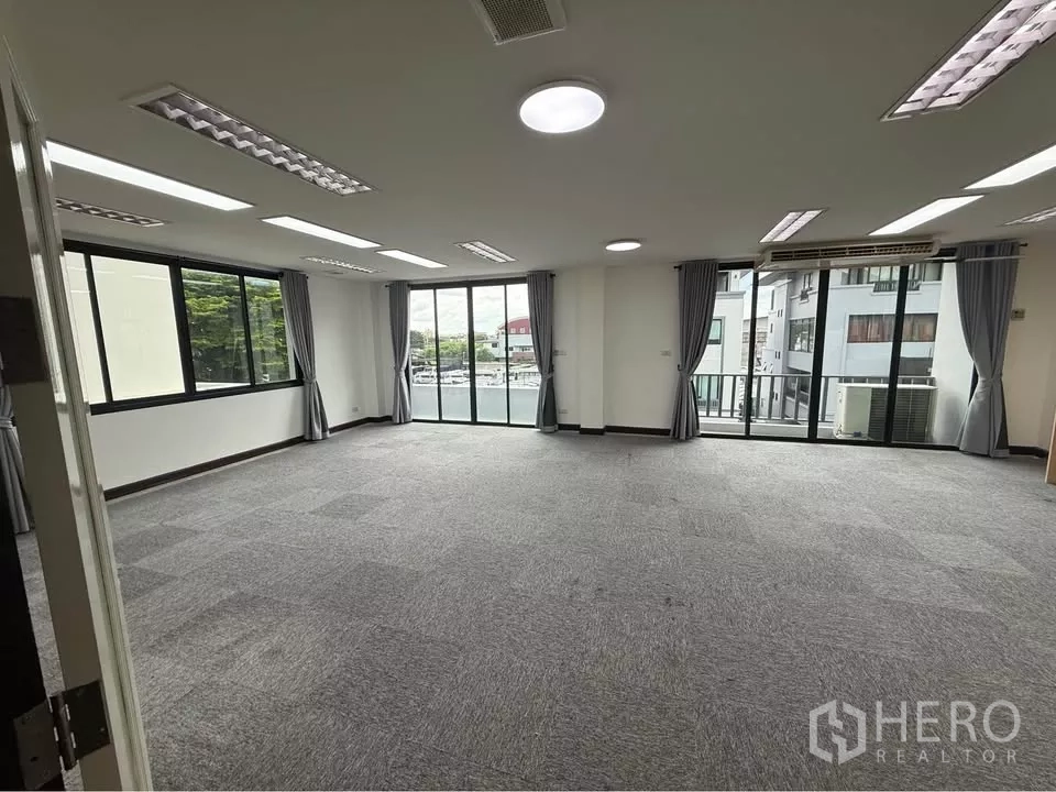 Home Office for rent in Wang Thonglang, Bangkok - Carpeted office floor with LED lighting, large windows and balcony access.