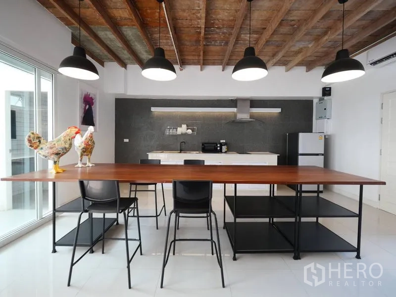 ทาวน์เฮาส์ ให้เช่าในKhlong Toei, Bangkok - ครัวเปิดของทาวน์เฮ้าส์ย่านพระโขนง โต๊ะรับประทานยาว โคมแขวน เพดานไม้ และเครื่องใช้ทันสมัย