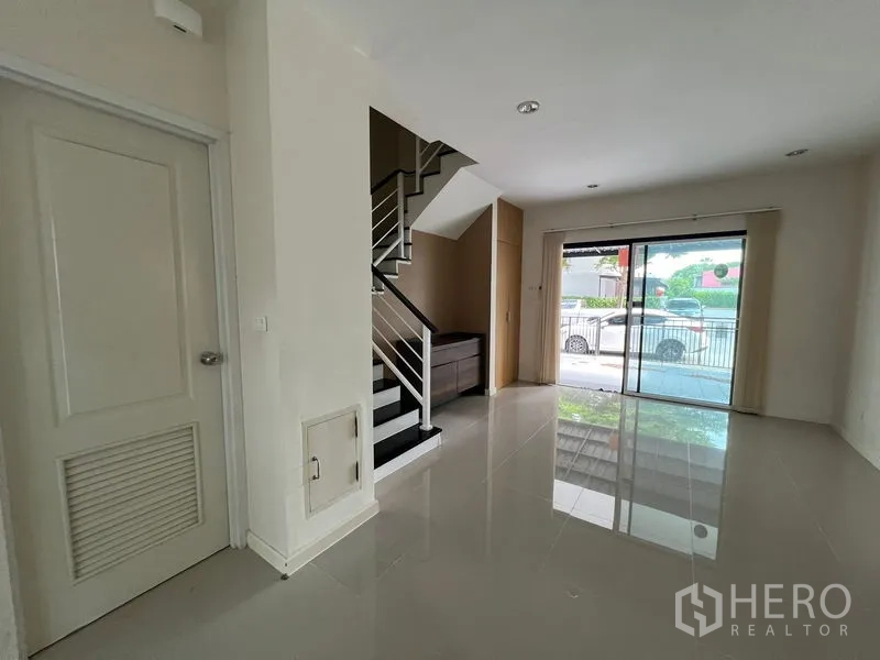 Townhouse for rent in Bang Kapi, Bangkok - Ground floor living area with staircase and sliding door to front porch.