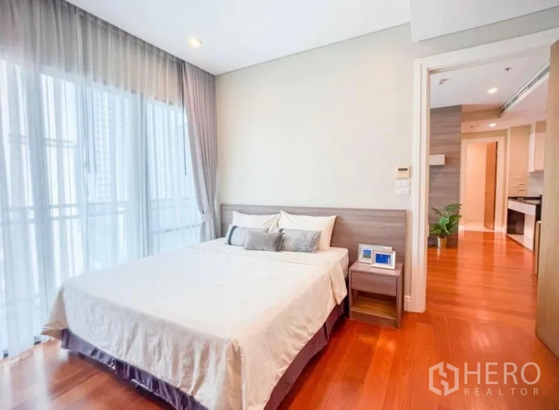 คอนโด ให้เช่าในKhlong Toei, Bangkok - ห้องนอนหลักเตียงคู่ หน้าต่างสูงระดับระเบียง และโต๊ะหัวเตียง