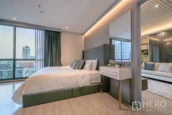 Condominium for rent in Watthana, Bangkok - Master bedroom with large windows, upholstered headboard, and balcony city views.