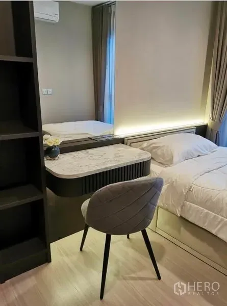 Condominium for rent in Huai Khwang, Bangkok - Cozy bedroom with dressing table, mirror, and soft lighting beside a window