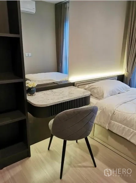 Condominium for rent in Huai Khwang, Bangkok - Cozy bedroom with dressing table, mirror, and soft lighting beside a window