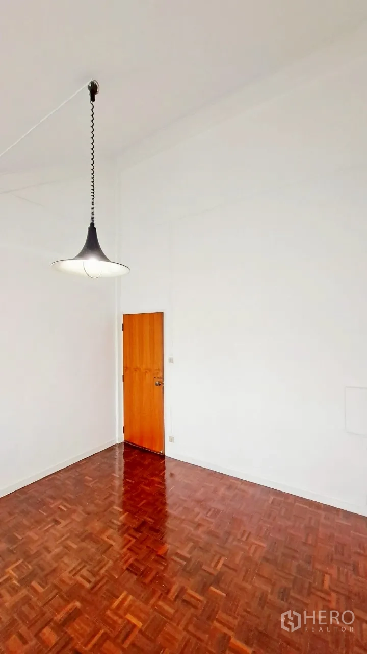 Townhouse for rent in Watthana, Bangkok - Bedroom with high ceiling, pendant light and polished parquet floor.