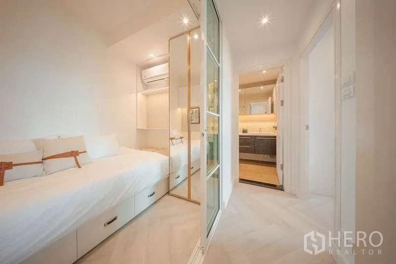 คอนโด ให้เช่า - ห้องนอนที่สองแบบเตียงลิ้นชัก มีประตูกระจกบานเลื่อน เห็นห้องน้ำด้านหน้า