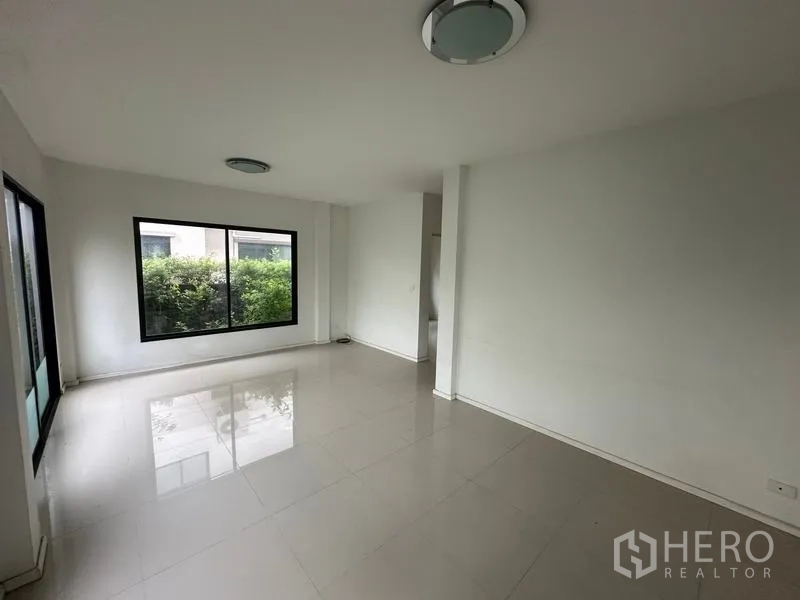 บ้าน ขายในBang Khen, Bangkok - ห้องนั่งเล่นมุมที่สองพร้อมหน้าต่างบานใหญ่รับวิวสวน.