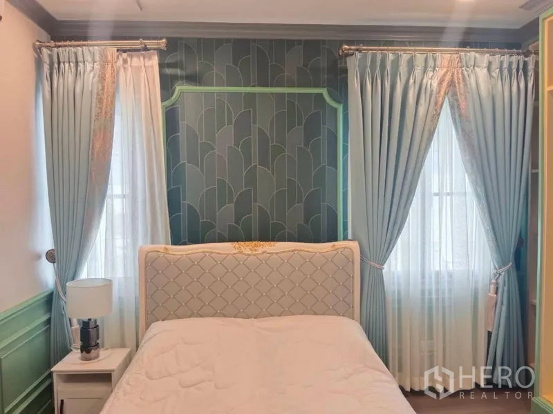 Detached House for rent or sale in Saphan Sung, Bangkok - Guest bedroom with teal accent wall, elegant curtains and soft lighting.