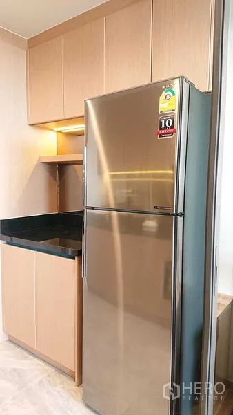 คอนโด ขายในWatthana, Bangkok - มุมครัวพร้อมตู้สูงลายไม้และตู้เย็นสแตนเลสแบบสองประตู