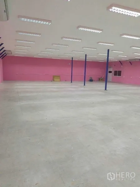 Warehouse for rent in Khlong Luang, Pathum Thani - Spacious storage area showing polished concrete floor and long LED-lit ceiling.
