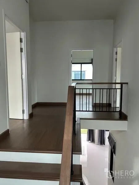 Detached House for sale in Khlong Sam Wa, Bangkok - Bright upper landing with wood floors and a stair railing connecting bedrooms