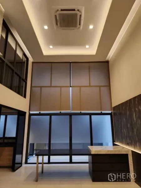 ทาวน์เฮาส์ ขายในYan Nawa, Bangkok - ห้องนั่งเล่นแบบโอเพ่นพร้อมฝ้าหลุม แอร์แขวน และหน้าต่างกระจกเต็มบานพร้อมม่าน.