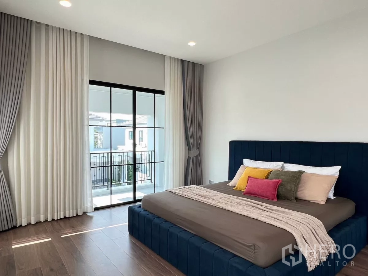 บ้าน ให้เช่าในKhan Na Yao, Bangkok - ห้องนอนใหญ่ เตียงกำมะหยี่สีน้ำเงิน ประตูกระจกบานเลื่อนไปยังระเบียงส่วนตัว