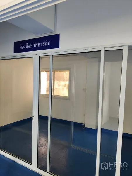 货栈 出租在Bueng Kum, Bangkok - 玻璃隔断工作区，白色墙面与窗户采光。