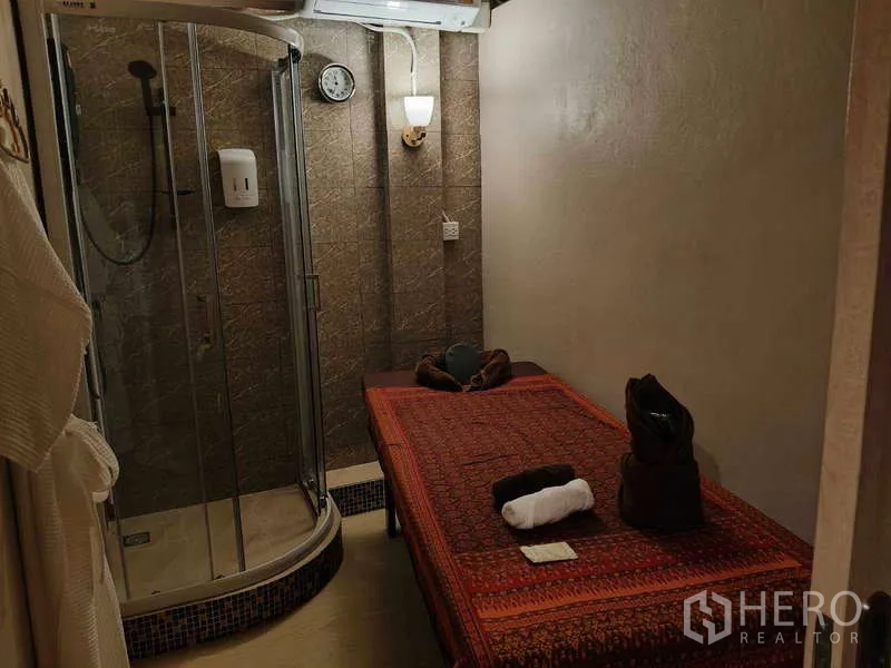 店屋 出租或出售在Watthana, Bangkok - 带淋浴房的理疗室，置有按摩床。