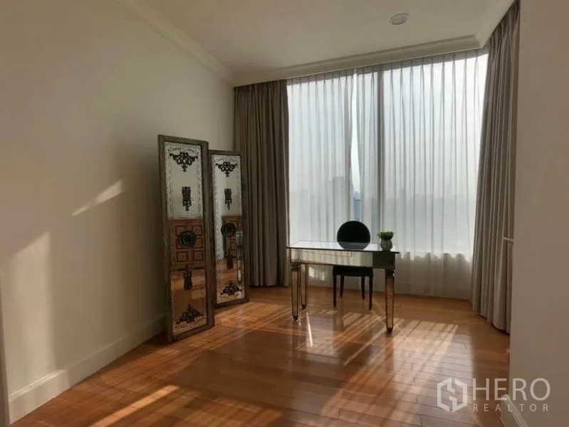 Condominium for rent in Watthana, Bangkok - Sunlit multipurpose room with desk, wood floors and full-height curtains.