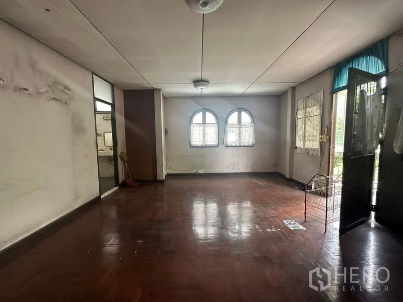 บ้าน ขายในPhra Khanong, Bangkok - พื้นที่นั่งเล่นขนาดใหญ่ พื้นปาร์เกต์ หน้าต่างซุ้มโค้ง และทางออกสู่ระเบียง