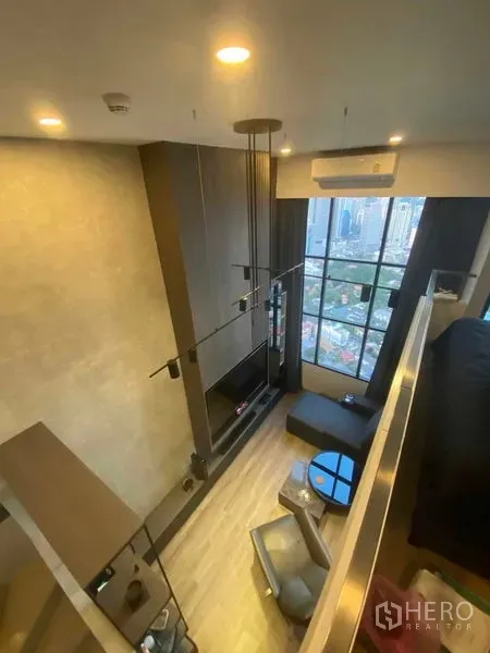 公寓 出租或出售在Sathon, Bangkok - Loft客厅，挑高天花与落地窗，俯瞰城市天际线。