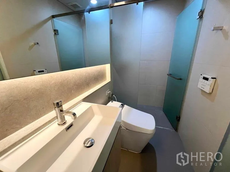 คอนโด ให้เช่าหรือขาย - ห้องน้ำพร้อมอ่างล้างหน้ายาว กระจกไฟซ่อน และตู้กั้นอาบน้ำกระจก