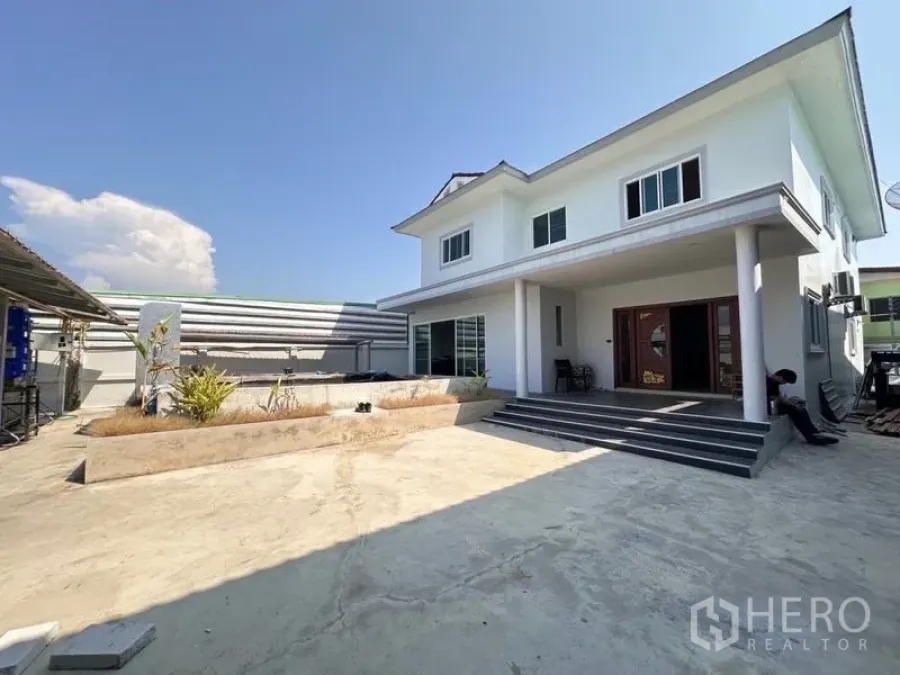Warehouse for sale in Bang Phli, Samut Prakan - Private two-storey residence inside the compound with wide steps and a large paved courtyard for parking.