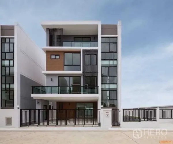 Home Office for rent or sale in Bang Phli, Samut Prakan - Front elevation of a new home office showing large windows, black metal fence and wide driveway.