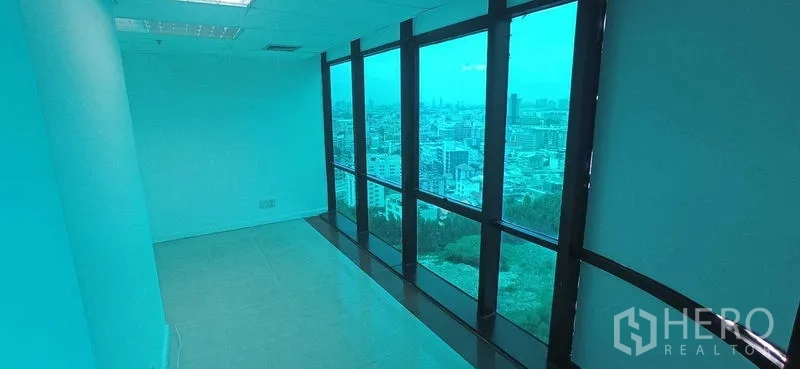 办公空间 出租在Huai Khwang, Bangkok - 狭长临窗房间，整面落地玻璃，开阔城市天际线景观。