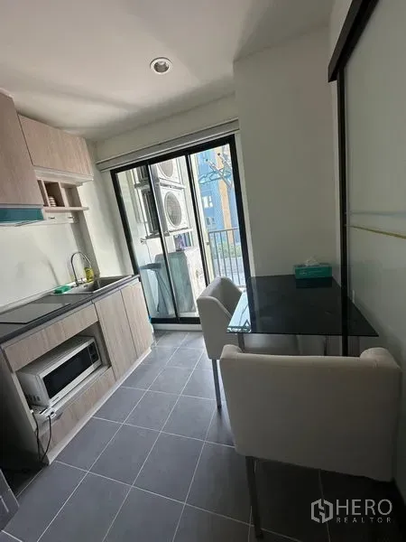 คอนโด ขายในKhlong Toei, Bangkok - มุมรับประทานอาหารสว่างด้วยโต๊ะกระจก เก้าอี้สองตัว เชื่อมต่อระเบียง