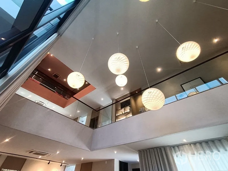 บ้าน ขาย - มุมมองจากชั้นบนของชั้นลอย เห็นโคมไฟทรงกลมและราวกันตกกระจก