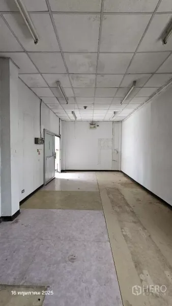 Retail Space for rent in Phra Khanong, Bangkok - Open retail hall with suspended ceiling and strip lighting, ready for renovation.